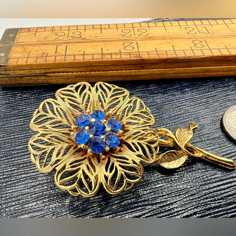 Vintage gold tone filigree flower brooch pin bright blue rhinestones